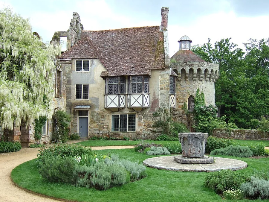 A manicured lawn with planted beds and topiary